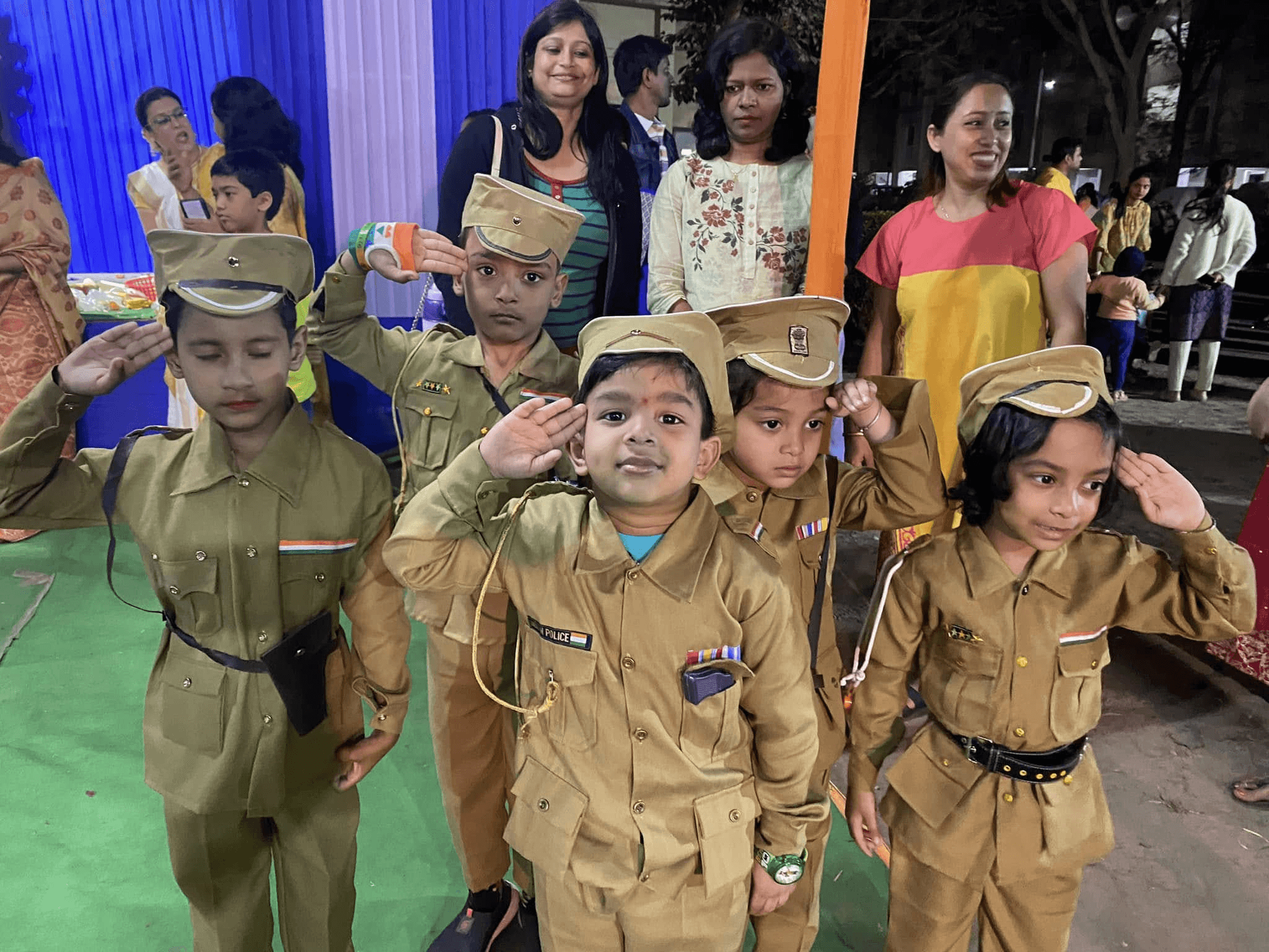 Children dressed as police officers saluting the flag